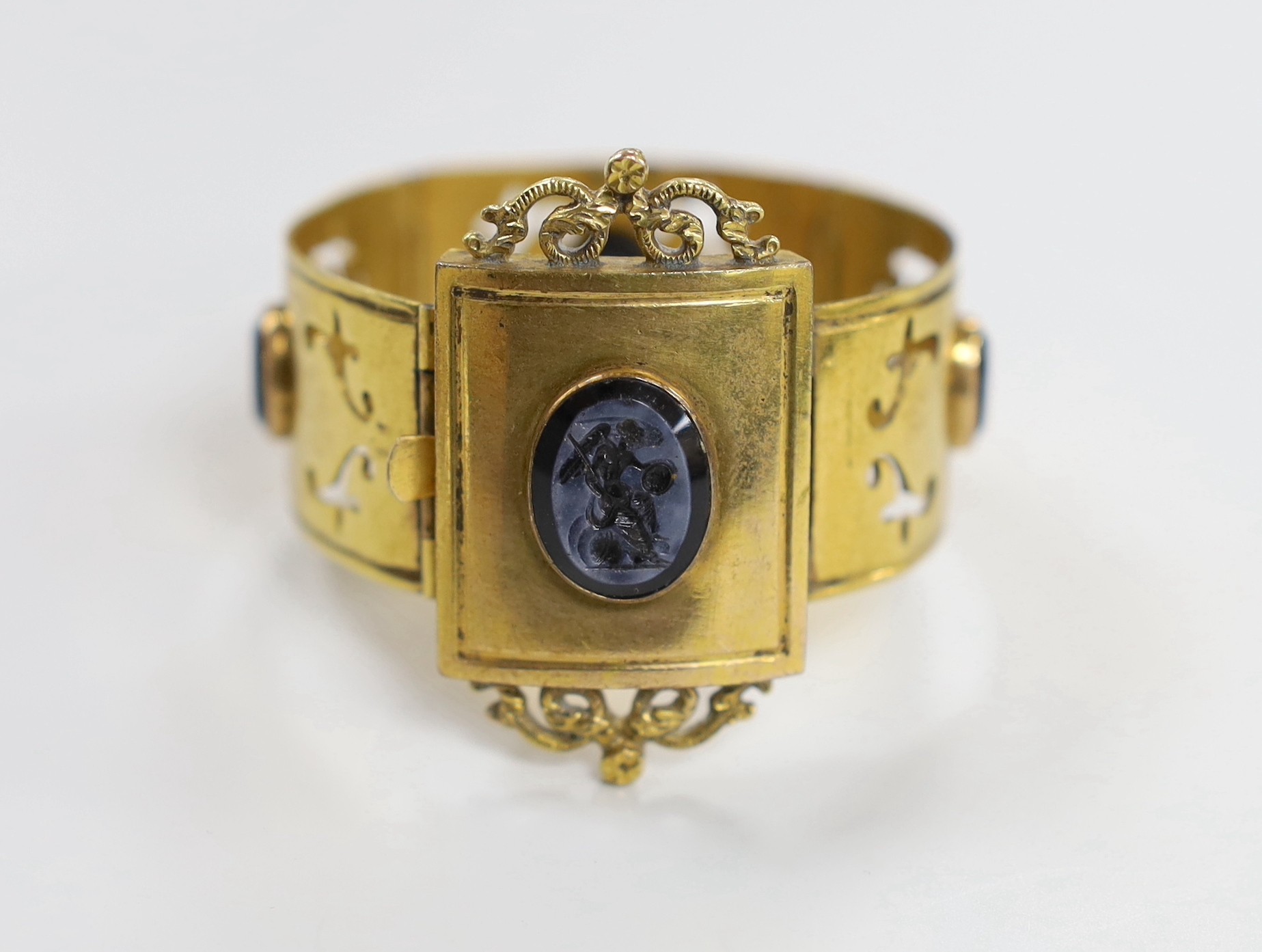 A Victorian gilt metal and four stone glass intaglio set bracelet, (repair), each stone carved with a cherub, 15cm.